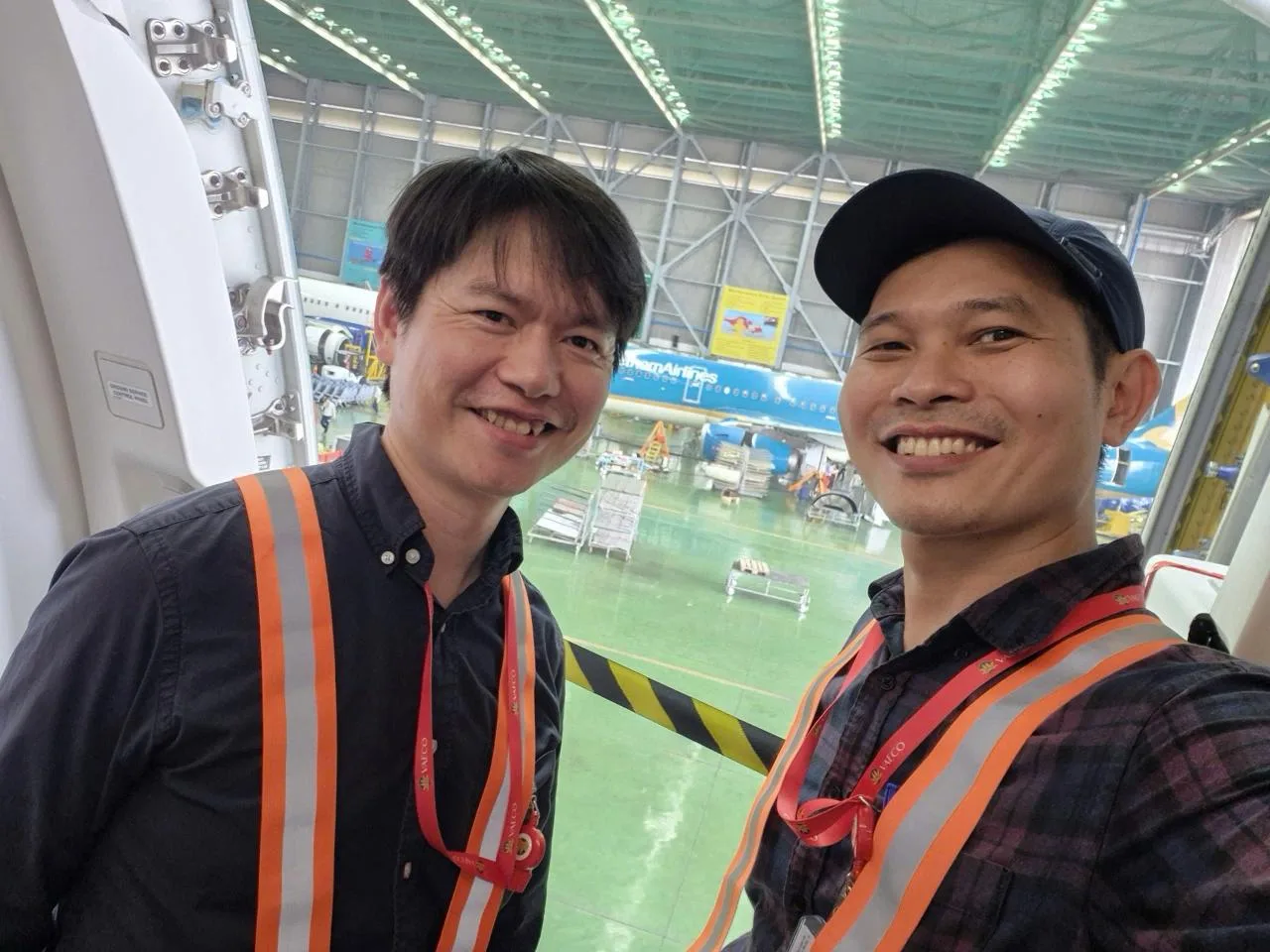 Hai thành viên ProMedia chụp ảnh selfie với máy bay Vietnam Airlines.