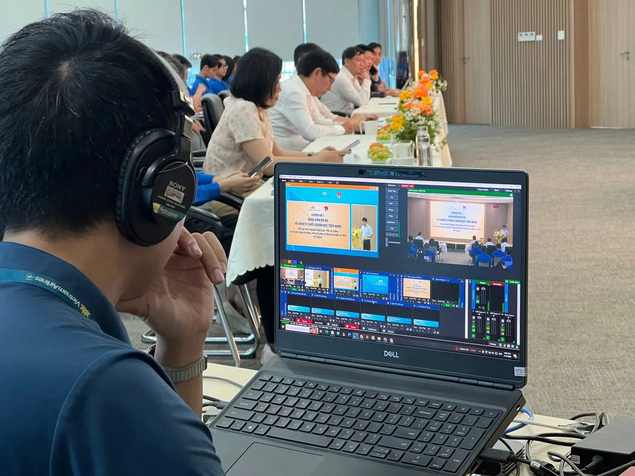Kỹ thuật viên lắp đặt hệ thống livestream hội nghị với laptop và nhiều nguồn tín hiệu