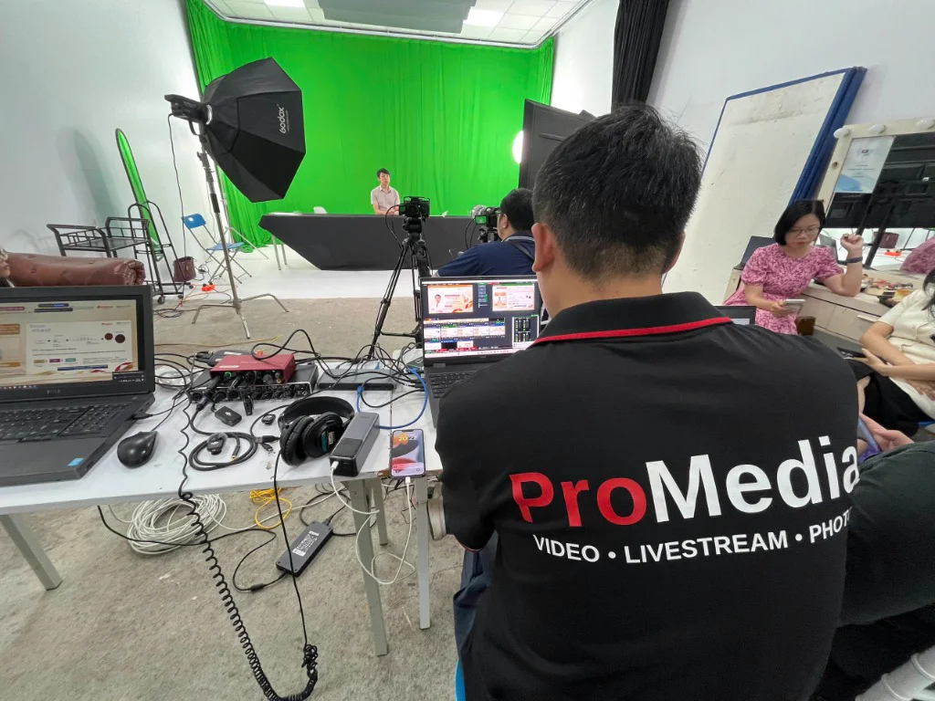 Hậu trường ekip ProMedia vận hành hệ thống ánh sáng đèn Godox và trường quay phông xanh