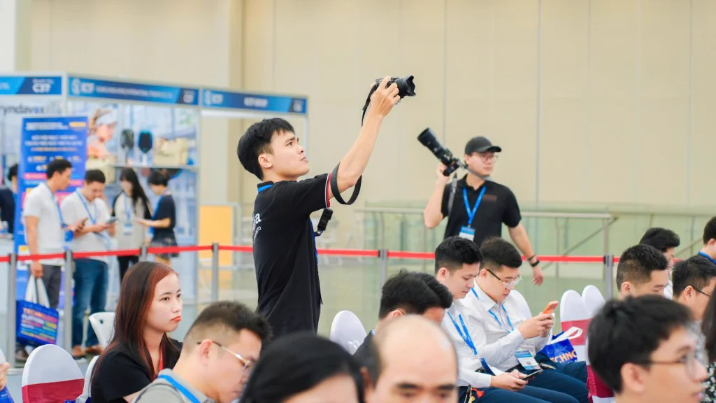 Nhiếp ảnh gia ProMedia tác nghiệp góc cao chụp toàn cảnh đại biểu tham dự triển lãm