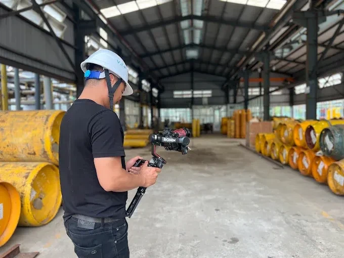 Gimbal operator filming inside industrial plant hall